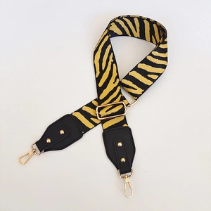 Adjustable wide replacement bag strap with black and yellow zebra stripes and gold buckles