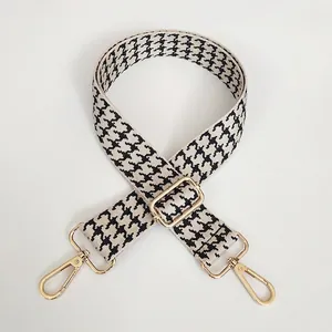 Detail of adjustable wide shoulder strap featuring black and white houndstooth jacquard weaving