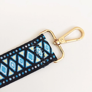 Macro detail of geometric ethnic bag strap with high-quality gold swivel lobster clasp