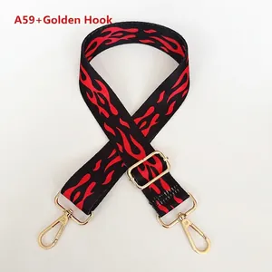 Detail of adjustable woven bag strap with red flame pattern and golden metal lobster clasps