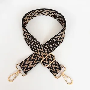 Détail de la bandoulière réglable A75 avec crochets dorés et motif géométrique marron