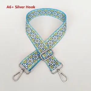 Detail view of ethnic blue floral wide strap with white daisies and silver metal hooks