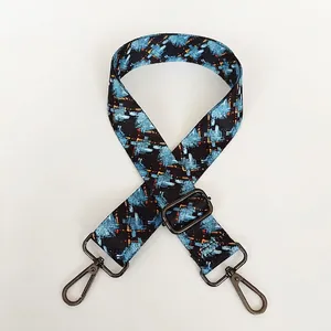 Detail of adjustable wide shoulder strap with blue and orange geometric pattern and metal hooks