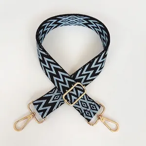 Détail de la bandoulière réglable tissée à motifs de vagues bleu-noir avec crochets dorés