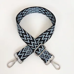 Détail de la bandoulière large réglable avec motifs tissés géométriques bleu et noir