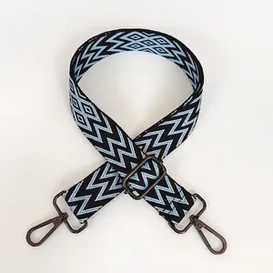 Détail de la bandoulière tissée ajustable avec motifs géométriques noirs et bleus et crochet métal