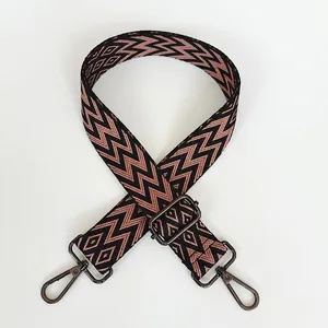 Détail d'une bandoulière ajustable à motif géométrique et fermoir mousqueton gris