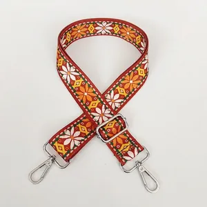 Close-up of ethnic style red woven bag strap with white daisies and silver metal clasps