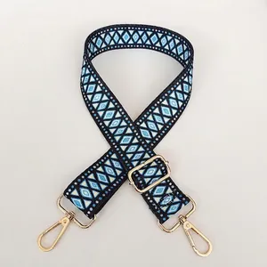 Close-up of ethnic blue and white geometric woven wide strap with gold metal hooks