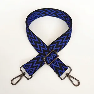 Détail de la bandoulière tissée bleue et noire avec motifs géométriques et crochets