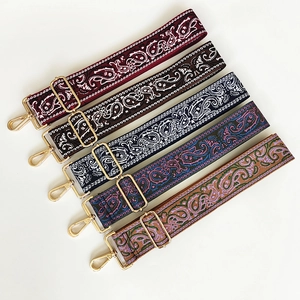 Close-up of five colorful paisley canvas bag straps with gold metal hooks and hardware