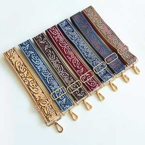 Close-up of colorful paisley patterned canvas bag straps with gold metal hardware adjusters