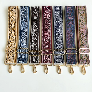 Close-up of paisley pattern canvas bag straps with gold metal lobster clasps