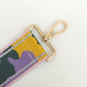 Detail of colorful jacquard nylon strap with gold metal lobster clasp for bags