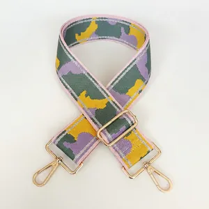 Close-up of wide nylon replacement strap with colorful geometric weave and gold metal hooks