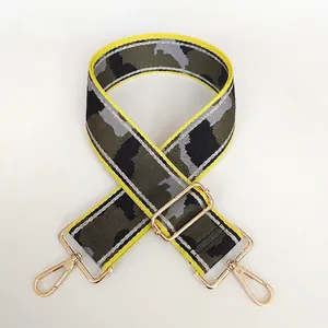 Detail of camo nylon bag strap with yellow edges and gold-tone adjustable metal buckles