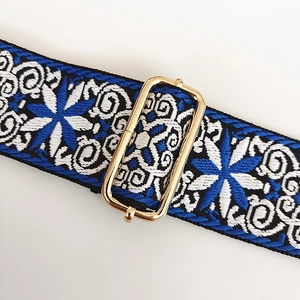 Détail d'une bandoulière brodée ethnique bleue et blanche avec boucle en métal doré