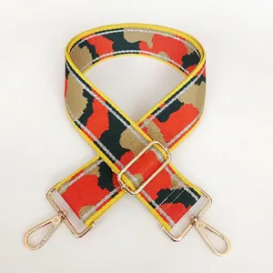 Close-up of adjustable camo nylon strap with gold swivel hooks and yellow edging trim