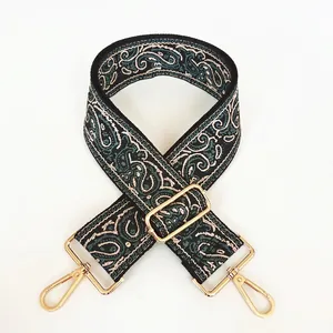 Detailed view of No. 18 green paisley canvas strap with gold lobster claw hooks