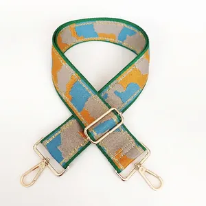 Detail of colorful camo nylon wide shoulder strap with golden metal swivel hooks