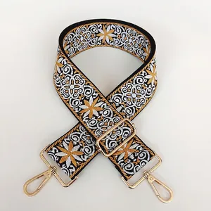 Détail de bandoulière brodée style ethnique avec motifs floraux et crochets dorés