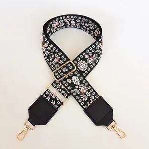 Détail de la bandoulière brodée florale ajustable avec cuir noir et crochets dorés