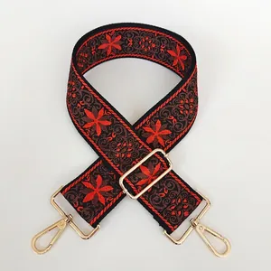 Détail de la broderie florale ethnique rouge et marron sur une large bandoulière