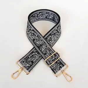 Detail of 5cm wide paisley canvas bag strap with golden snap hooks and adjusters