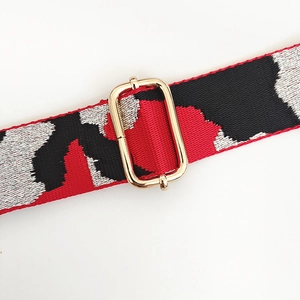 Macro shot of colorful woven shoulder strap with polished gold adjustable buckle