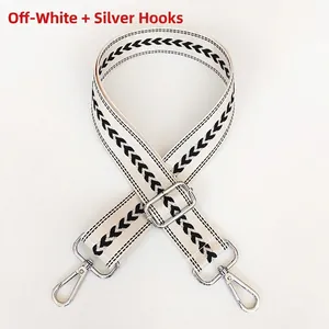 Detail of cream white jacquard bag strap with heart pattern and silver metal swivel hooks