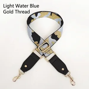 Detail of adjustable blue and gold camo strap with black leather and metal swivel hooks