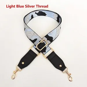 Detail of adjustable camouflage bag strap in light blue and silver with gold lobster clasps