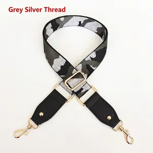 Adjustable camouflage bag strap with grey silver threads and gold metal buckles