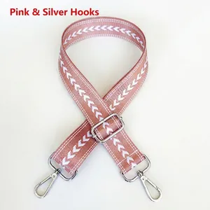 Detail of pink nylon shoulder strap with white jacquard arrow pattern and silver hooks