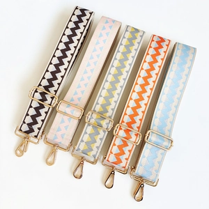 Detailed view of adjustable ethnic style wide woven shoulder straps with gold metal hardware