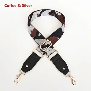 Detail of adjustable camo wide strap with gold buckle and brown leather end for handbags