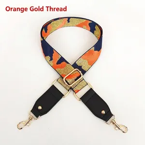 Detail of adjustable orange and navy camo strap with gold thread and metal buckles