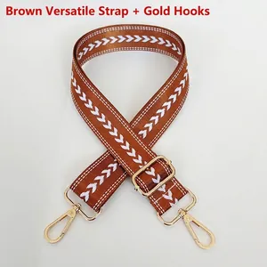 Detail of brown nylon strap with white arrow pattern and golden metal swivel hooks