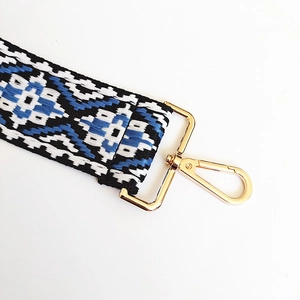 Macro detail of ethnic blue geometric woven strap with gold metal lobster clasp