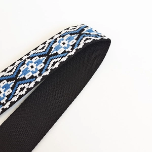 Close-up of geometric pattern nylon bag strap with durable weave and black lining