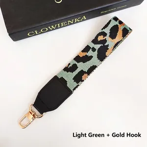 Close-up of wide polyester leopard print strap with gold lobster clasps and leather ends