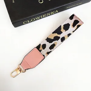 Close-up of leopard print phone strap with pink PU leather and gold metal hook