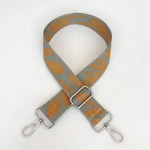 Detail of adjustable gray strap with orange floral pattern and silver metal hooks