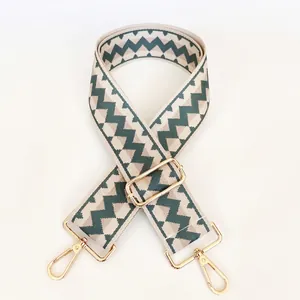 Close-up of zigzag geometric jacquard pattern webbing strap with golden metal swivel hooks