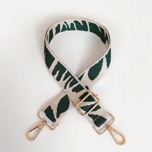 Detail of green zebra pattern embroidered canvas bag strap with gold metal buckle