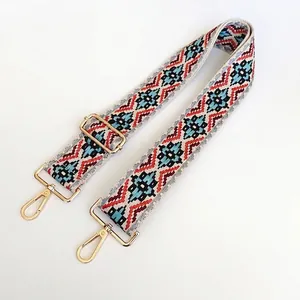Close-up of ethnic geometric pattern woven strap with gold metal hooks and buckle
