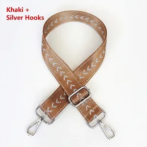Detail of khaki nylon bag strap with silver V-pattern and adjustable metal lobster hooks