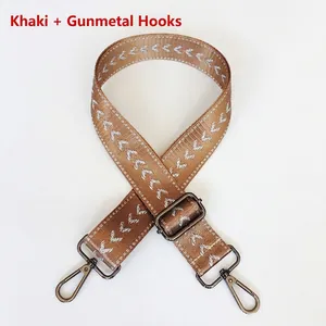 Detail of khaki adjustable nylon bag strap with silver arrow pattern and gunmetal hardware
