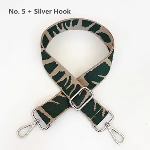 Detail of adjustable wide woven bag strap in green and beige with silver lobster clasps