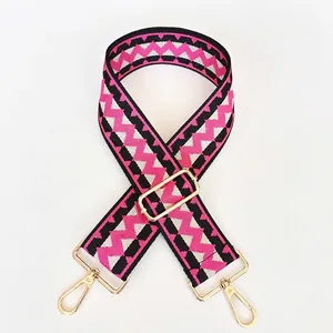 Detail view of adjustable pink and black chevron pattern wide bag strap with gold hooks